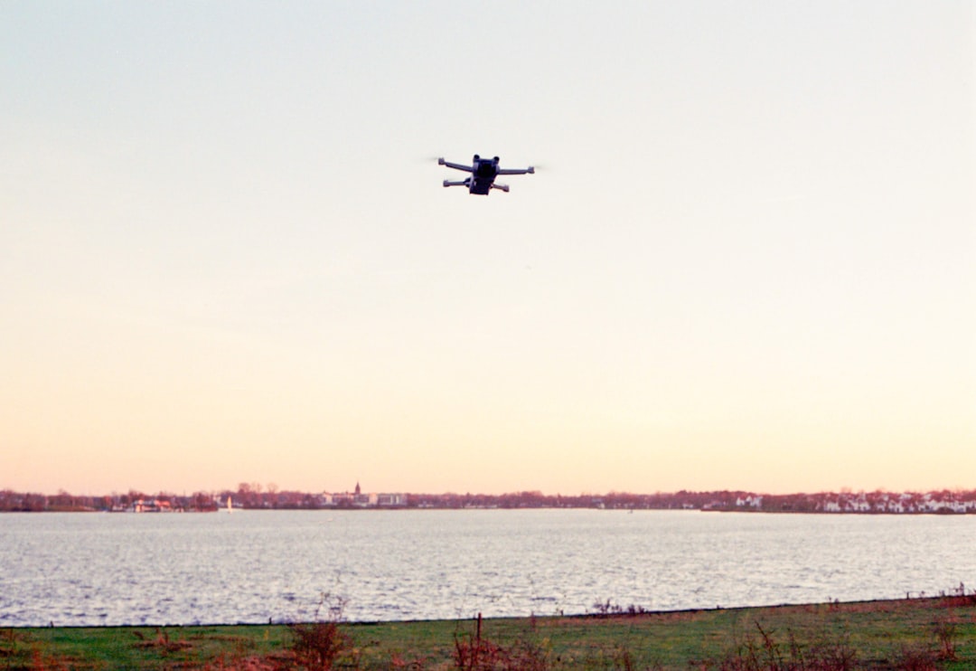 A drone flies over a lake.